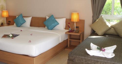 a bedroom with a bed and a table with flowers on it at U Tiny Boutique Hotel Suvarnabhumi Bangkok - SHA Plus in Lat Krabang