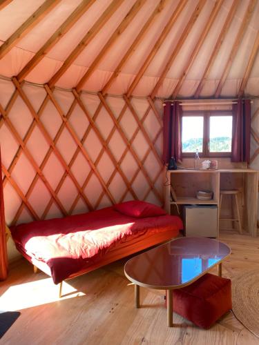 - une chambre avec un lit et une table dans une yourte dans l'établissement La Yourte contemporaine de M, à Saint-Pierre-Eynac