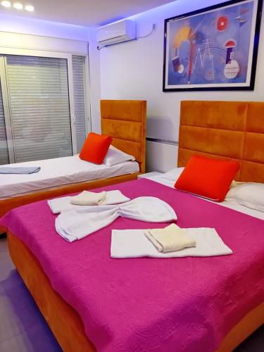 two beds in a room with red and white towels on them at Villa la vie in Ulcinj