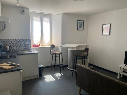Una cocina con encimera, mesa y sillas. en Duplex à inaugurer, en Florac
