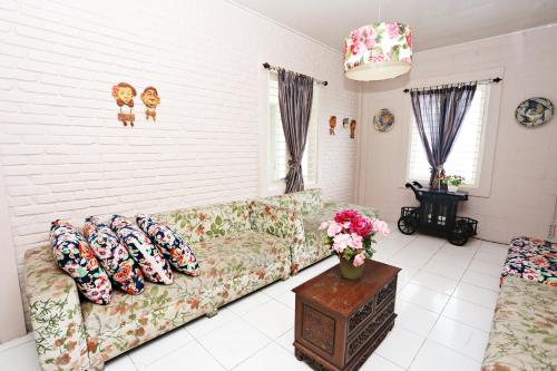a living room with a couch with pillows on it at Nusantara Bunga By Reccoma in Tengahgirang