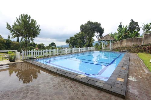 a large swimming pool with a white fence around it at Nusantara Bunga By Reccoma in Tengahgirang
