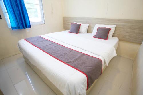 a bedroom with a large bed with two pillows at Nusantara Bunga By Reccoma in Tengahgirang