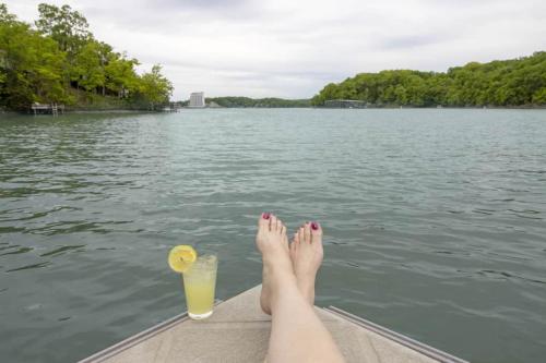 a woman with her feet up on a boat with a drink at Treetop Village100-3bed3bathindoor Pool8pp in Four Seasons