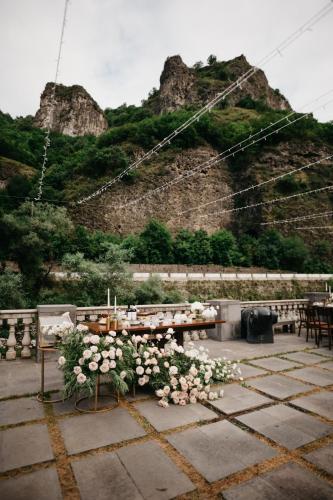 a table with flowers on it in front of a mountain at Tufenkian Avan Dzoraget Hotel in Dzoraget