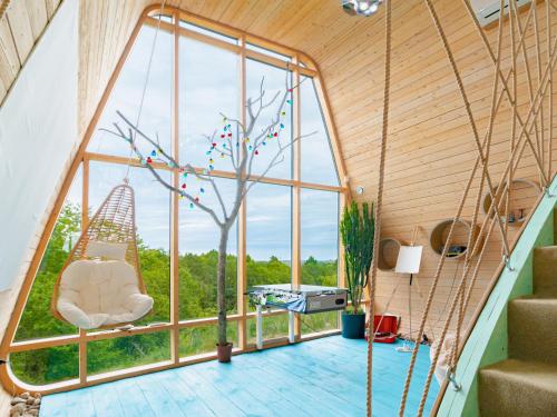 a room with a large window and a swing at Poilsio Arka in Nemaitonys