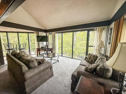 a living room with two couches and a large window at Treehouse Treetop Village101-3bed3bapools-8pp in Four Seasons