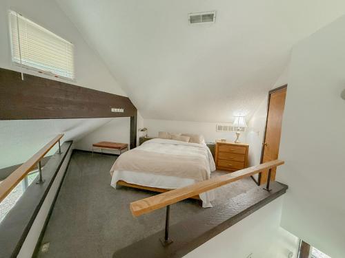 a attic bedroom with a bed and a staircase at Treehouse Treetop Village101-3bed3bapools-8pp in Four Seasons