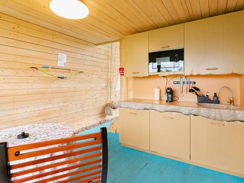 a kitchen with wooden walls and a bench in a room at Poilsio Arka in Nemaitonys