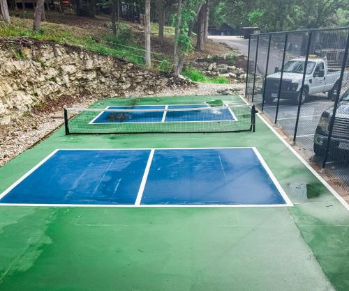 a tennis court is painted blue and green at Treehouse Treetop Village104-3bed3bapools-8pp in Four Seasons