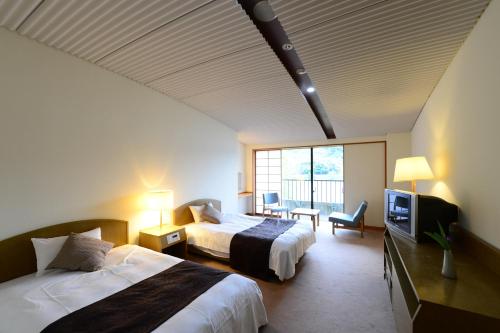 Habitación de hotel con 2 camas y TV en Suigekka en Wakasa