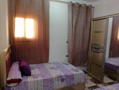 a small bedroom with a bed and a window at برج القط للشقق الفندقيه المفروشة in Marsa Matruh