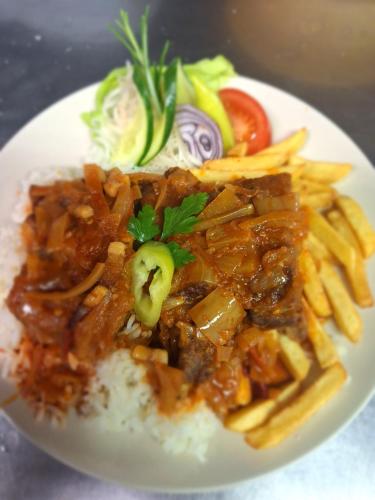 a plate of food with meat and french fries at Magyar Csárda és Vendégház in Harkány