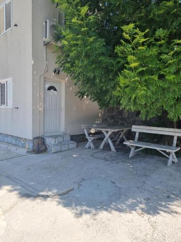 two picnic benches sitting next to a building at Porto Njeguši A1 in Cetinje