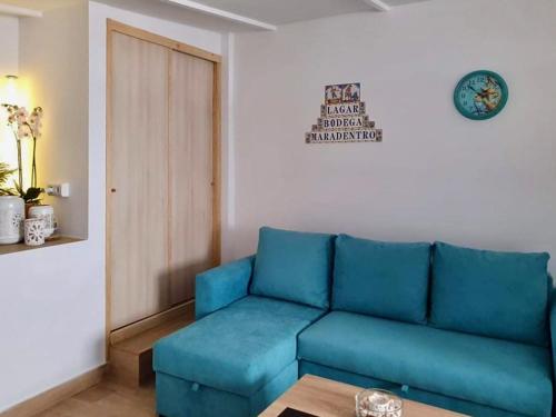 a living room with a blue couch and a table at Finca Maradentro - private pool and jacuzzi with ocean view in Arafo