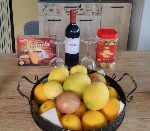 a bowl of fruit with a bottle of wine and a glass at Finca Maradentro - private pool and jacuzzi with ocean view in Arafo