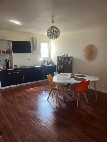 une cuisine avec une table et des chaises dans une pièce dans l'établissement Appartement chaleureux au cœur de la ville, à Saintes