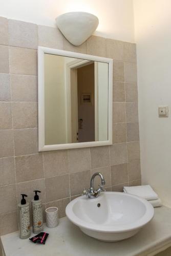 a bathroom with a sink and a mirror at Anthea Hotel in Tinos Town