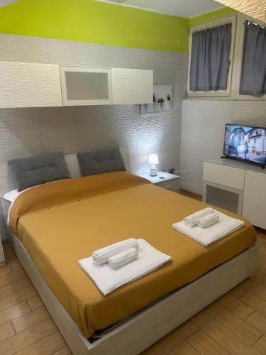 a bedroom with a large bed with towels on it at Salerno Costa D'Amalfi Rooms in Salerno