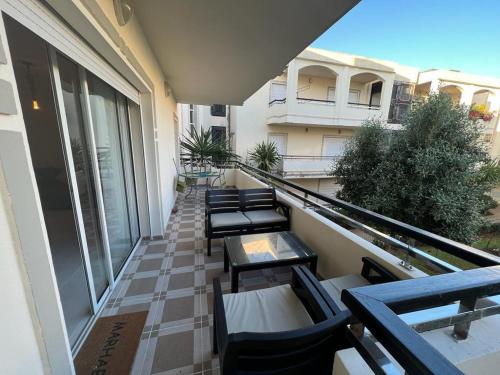 un balcon avec des chaises et des tables sur un immeuble dans l'établissement Magnifique Appartement Bahia Golf Beach, à Bouznika