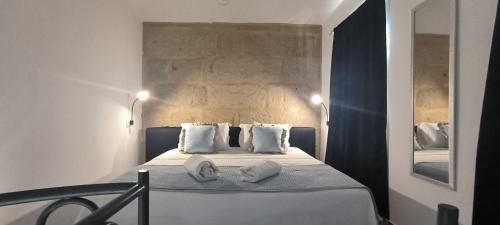 a bedroom with a bed with white sheets and pillows at La casita in Pontevedra