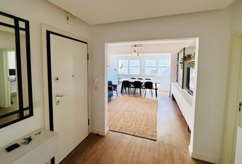 a hallway with a dining room and a dining table at NEW 3 Bedroom Beachfront Apartment in Carcavelos