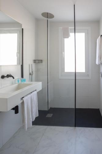 a white bathroom with a sink and a shower at Hotel Villa de Verín in Verín
