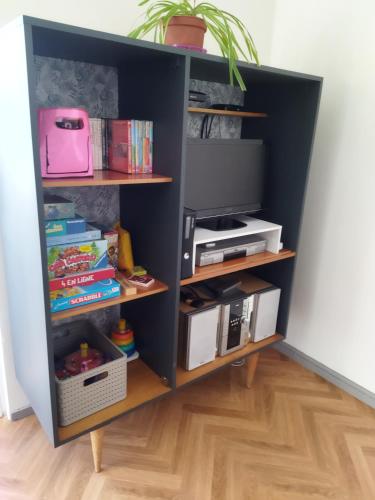 - une étagère noire avec une télévision dans l'établissement appartement pour famille amis ou colègue, à Cholet