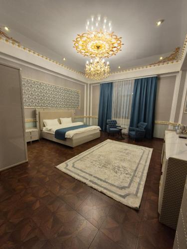 a large bedroom with a bed and a chandelier at Hotel Madonna SPA in Kaskelen