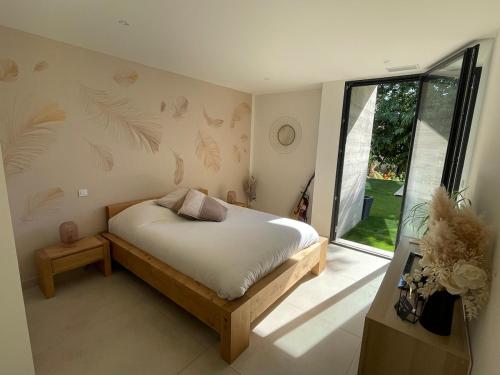 une chambre avec un lit et une grande fenêtre dans l'établissement Grande maison atypique avec piscine à débordement, à Bouillargues