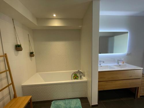 une salle de bain avec une baignoire et un lavabo dans l'établissement Grande maison atypique avec piscine à débordement, à Bouillargues