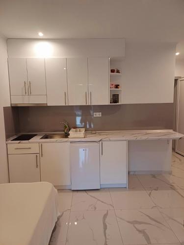 a kitchen with white cabinets and a counter top at Max in Ostrovo