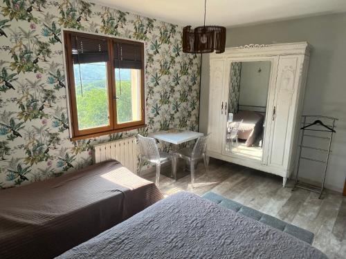 a bedroom with a bed and a table and a mirror at La paresse in Avèze