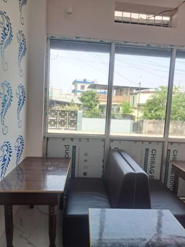 a room with a couch and a table and a window at Hotel Chaupari in Bākhri Kharka
