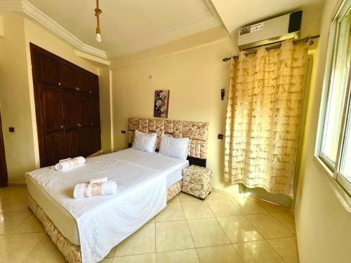 a bedroom with a bed with white sheets and a window at Appart Hotel Fes - Joud Families & Travelers in Fès