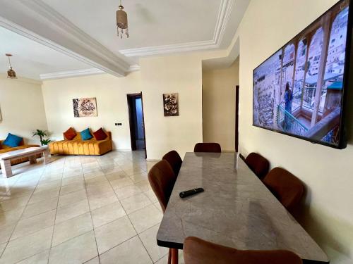 a living room with a table and a tv on the wall at Appart Hotel Fes - Joud Families & Travelers in Fès