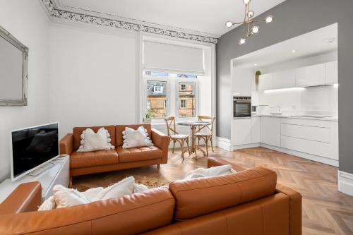 a living room with two brown couches and a table at Beautiful 1BR Super Central Apt with Period Features in Oban