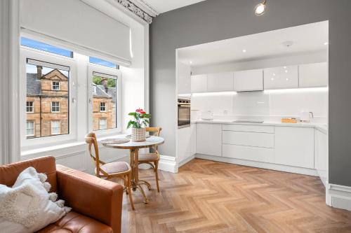 a kitchen with white cabinets and a table at Exceptional Central 1BR Apt - town square views in Oban