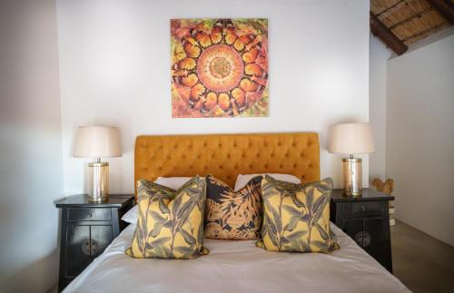 a bedroom with a bed with two night stands and two lamps at Sashwa River of Stars Plant-Based Wellness Safari Lodge in Hoedspruit