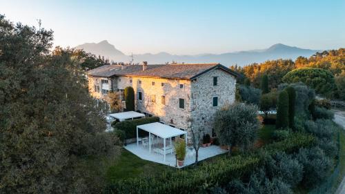 Una antigua casa de piedra con una mesa delante de ella. en The Romantic Dependance in Luxury Villa, en Torri del Benaco