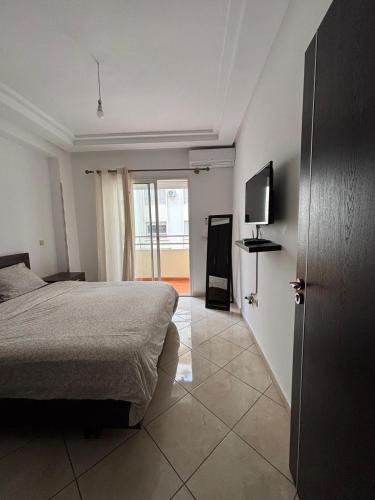 a bedroom with a bed and a flat screen tv at Magnifique Appartement Inès complexe Aida village in Tangier