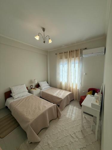 ein weißes Schlafzimmer mit 2 Betten und einem Fenster in der Unterkunft A nest for two in Athens in Mesochórion