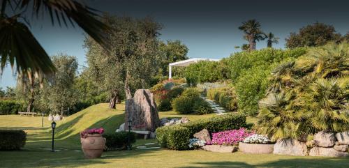 un jardín con plantas y flores en un parque en The Romantic Dependance in Luxury Villa, en Torri del Benaco