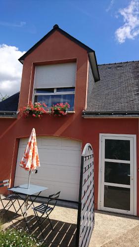 a house with a table and a chair in front of it at Ar Baradoz Bihan - studio meublé in La Celle-sous-Gouzon