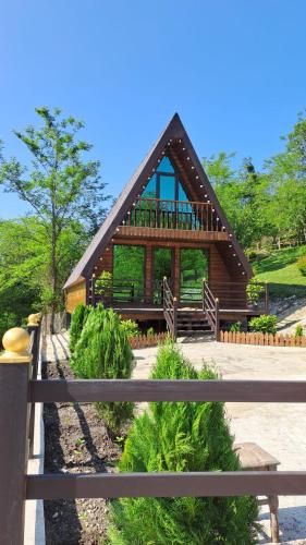 a small wooden house with a fence in front of it at Green Paradise Martvili Cottege in Martvili