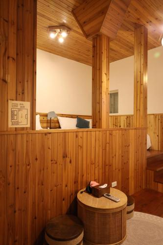 a sauna with a wooden wall and a round table at Fangshuh B&B in Fenglin