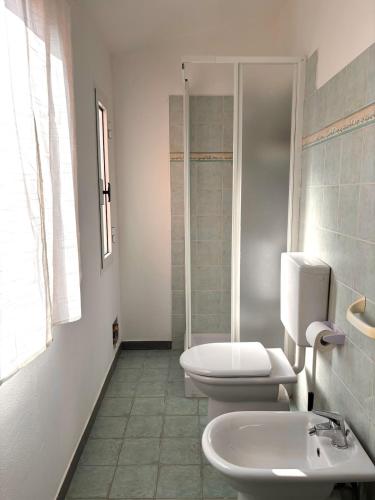 a white bathroom with two toilets and a shower at Trilocale a 100 m dal mare in Imperia