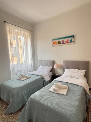 a bedroom with two beds with towels on them at Trilocale a 100 m dal mare in Imperia