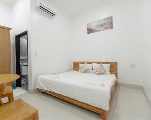 a bedroom with a bed in a white room at Hotel AN KHƯƠNG in Rach Gia