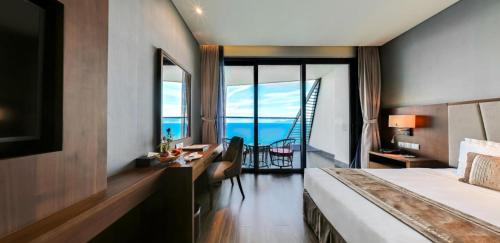 a hotel room with a bed and a view of the ocean at Boton Blue Hotel & Spa in Nha Trang